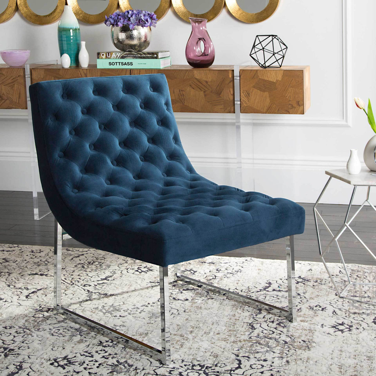 Deep navy velvet tufting and gleaming chrome legs bring plush style to a living space