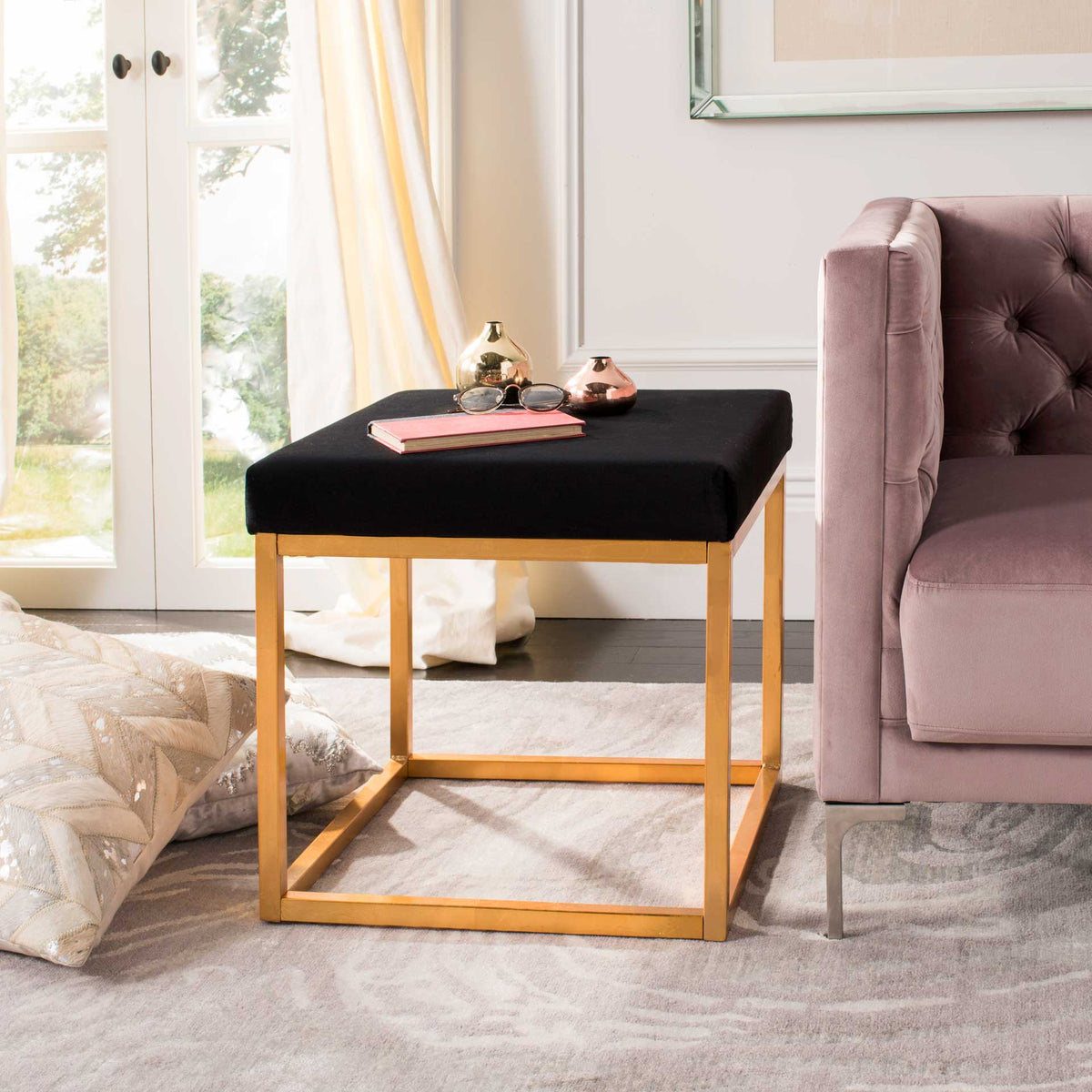 Black velvet and gold metal create a chic ottoman that also holds small decor.