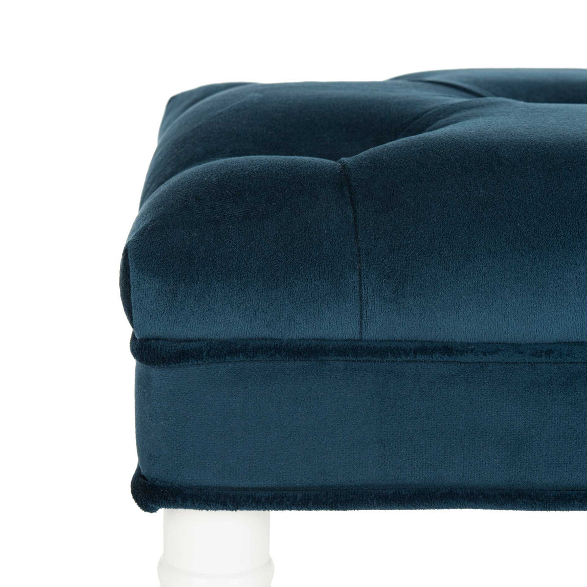 Plump navy velvet upholstery features deep tufting and neatly tailored cushion edges