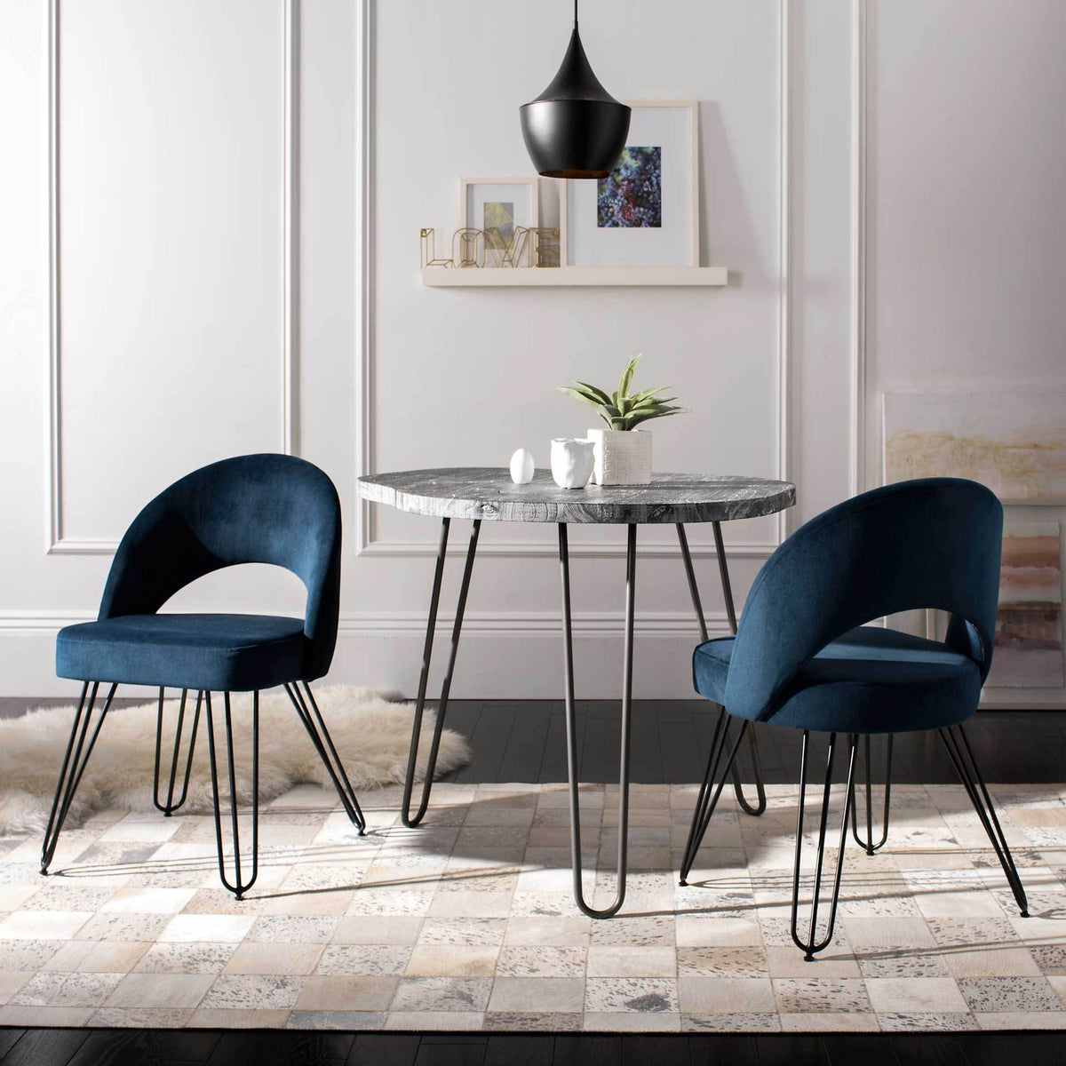 Navy velvet chairs add rich color, curved open backs and elegant hairpin legs to a dining space