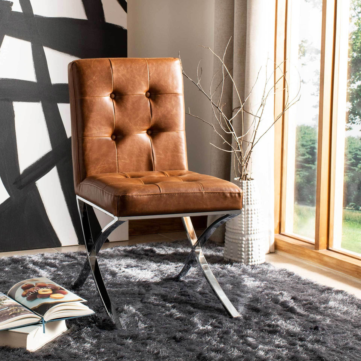 Warm brown button tufting and polished chrome curves bring contemporary comfort to a bright room
