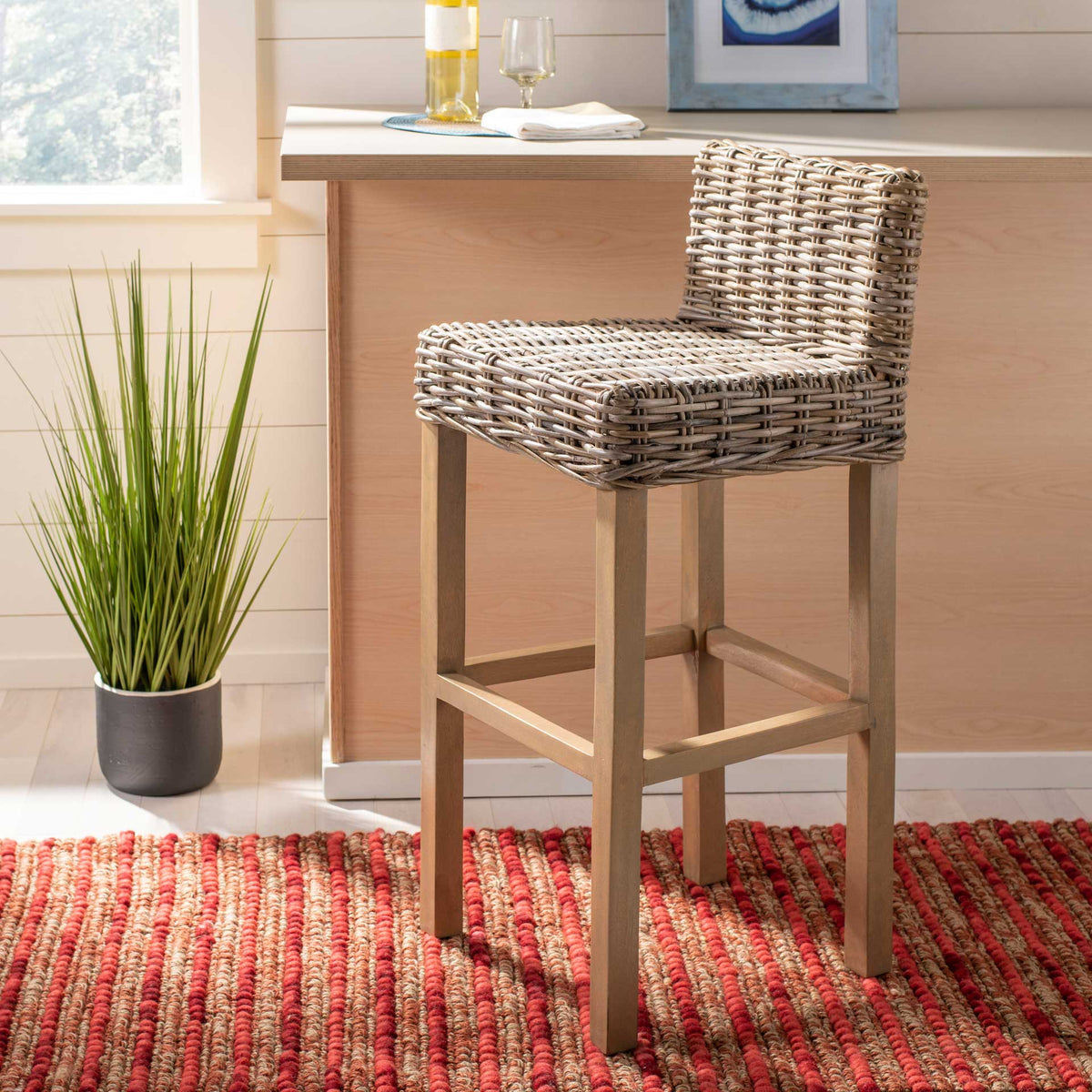 A woven taupe seat and natural wood frame add casual texture to a bright home bar.