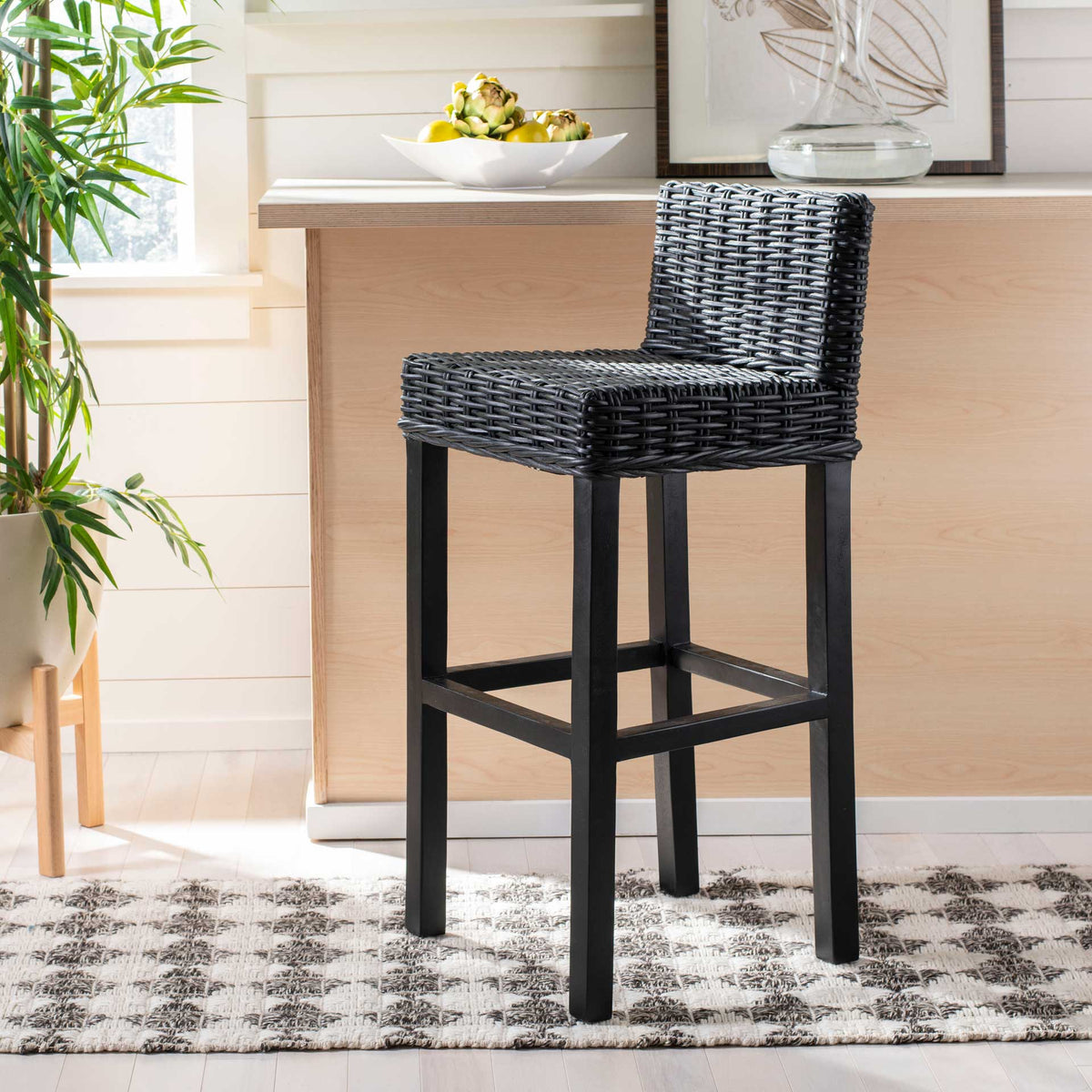A black woven seat brings bold texture to a pale wood breakfast bar.