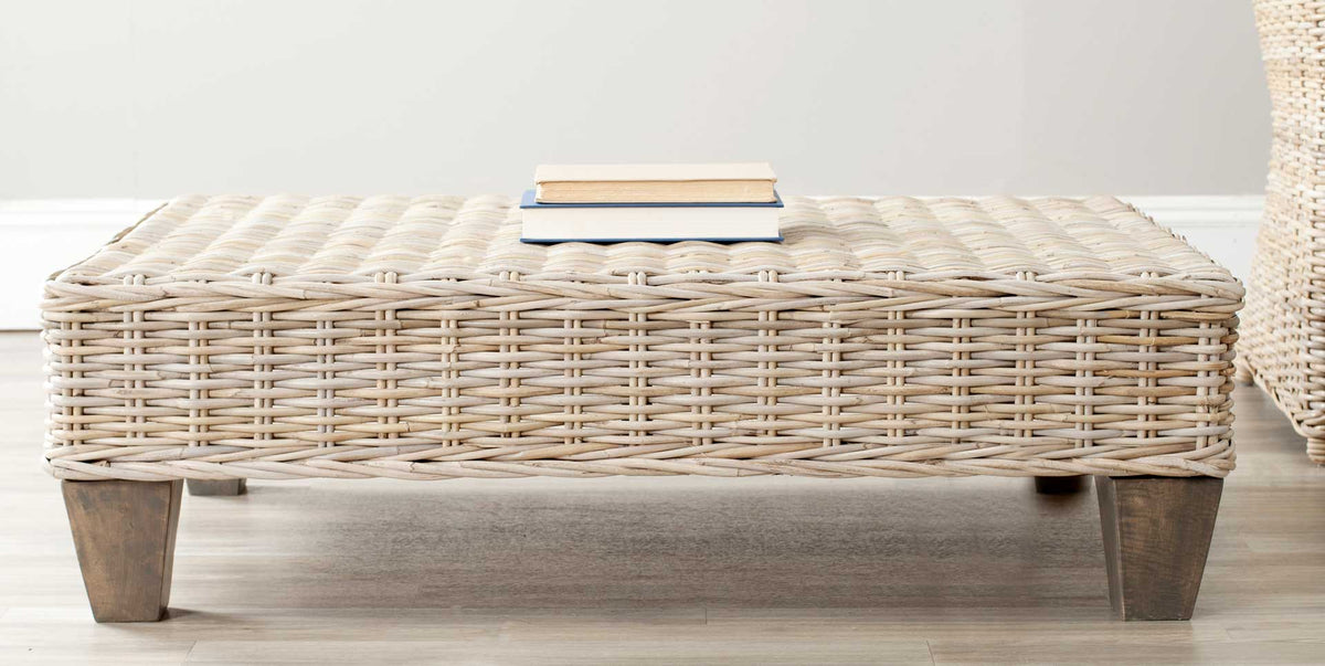 Pale woven rattan and taupe wood legs lend this coffee table a relaxed coastal look.