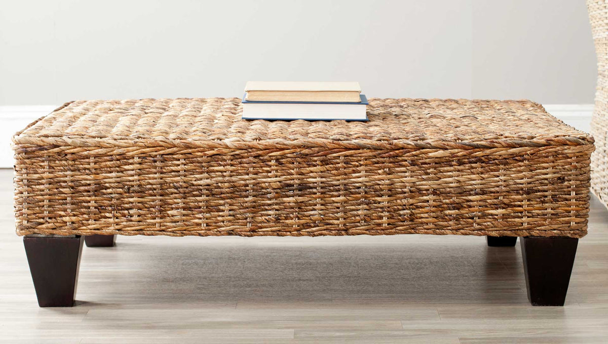 Natural banana rattan and dark brown wood legs give this coffee table a coastal feel.