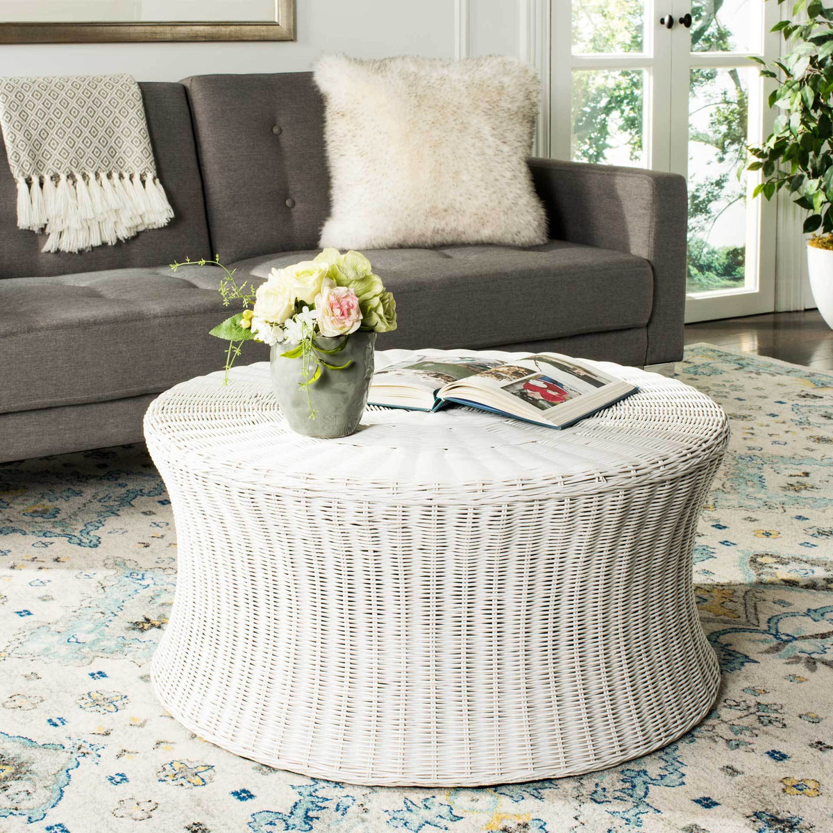 White rattan ottoman offers a generous tabletop and softly tapered sides