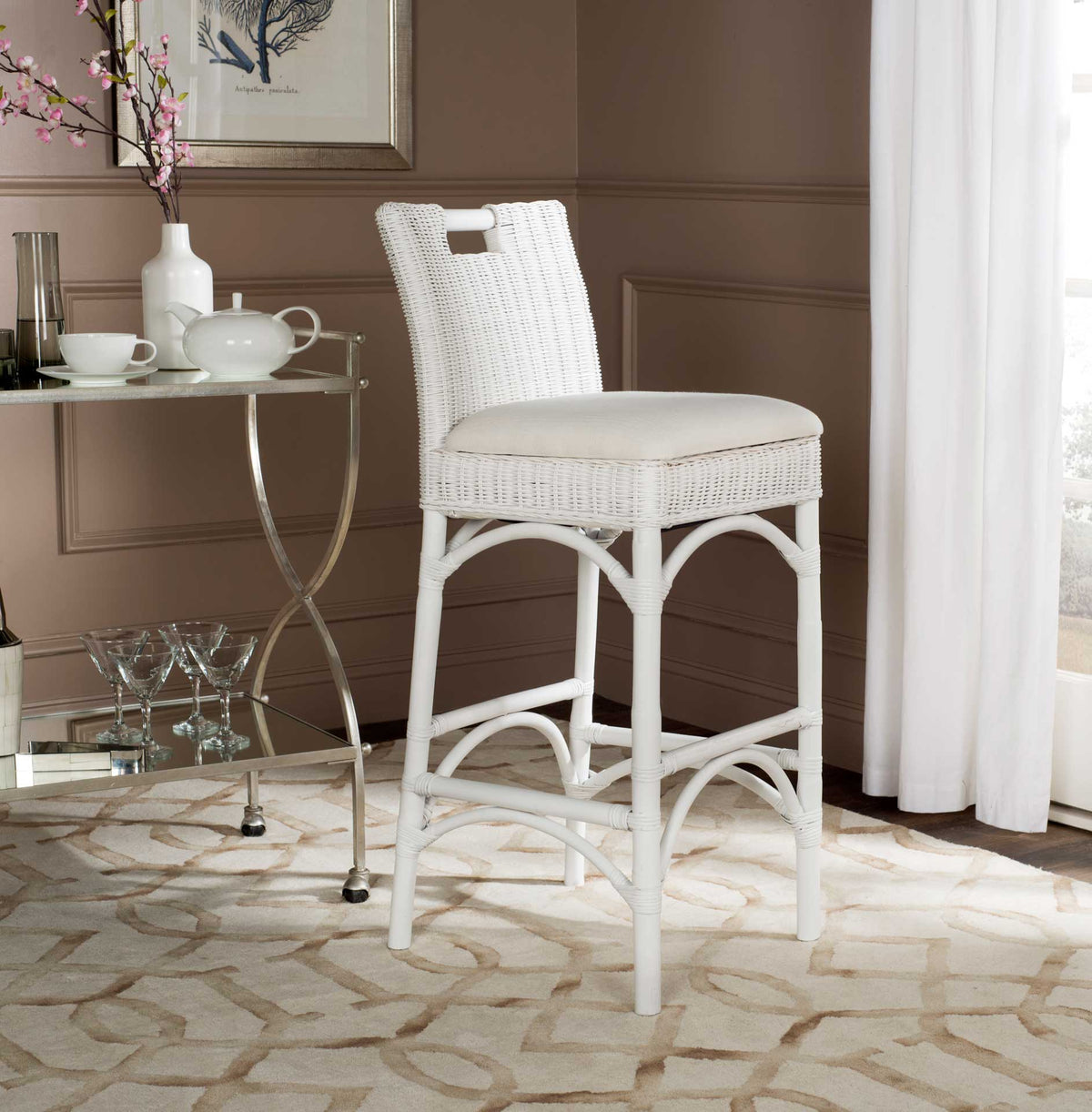 A bright white rattan stool adds coastal ease with its ivory seat, woven back and slender arched legs.