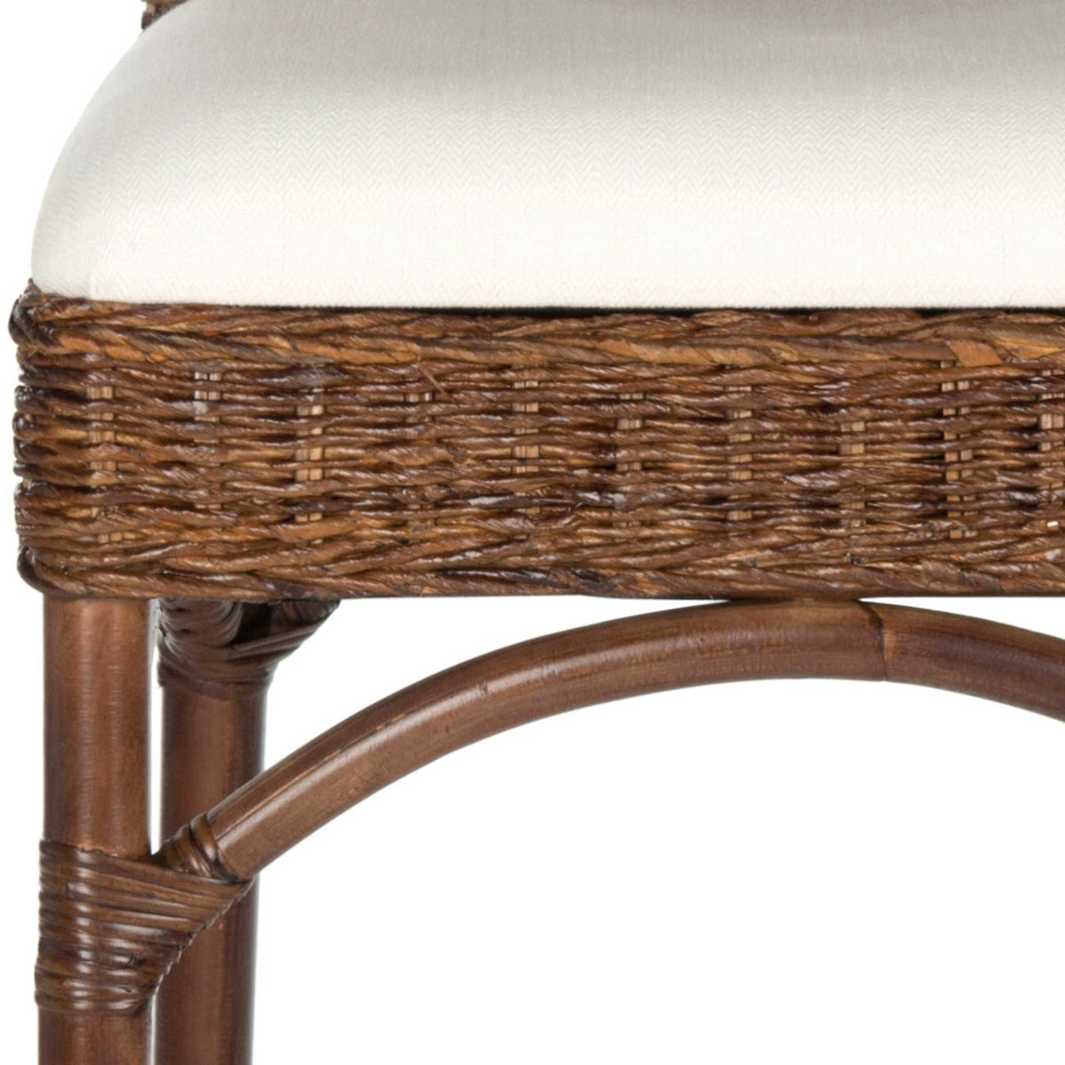 An ivory cushion rests on densely woven brown rattan, accented by a smooth arched brace and wrapped leg.
