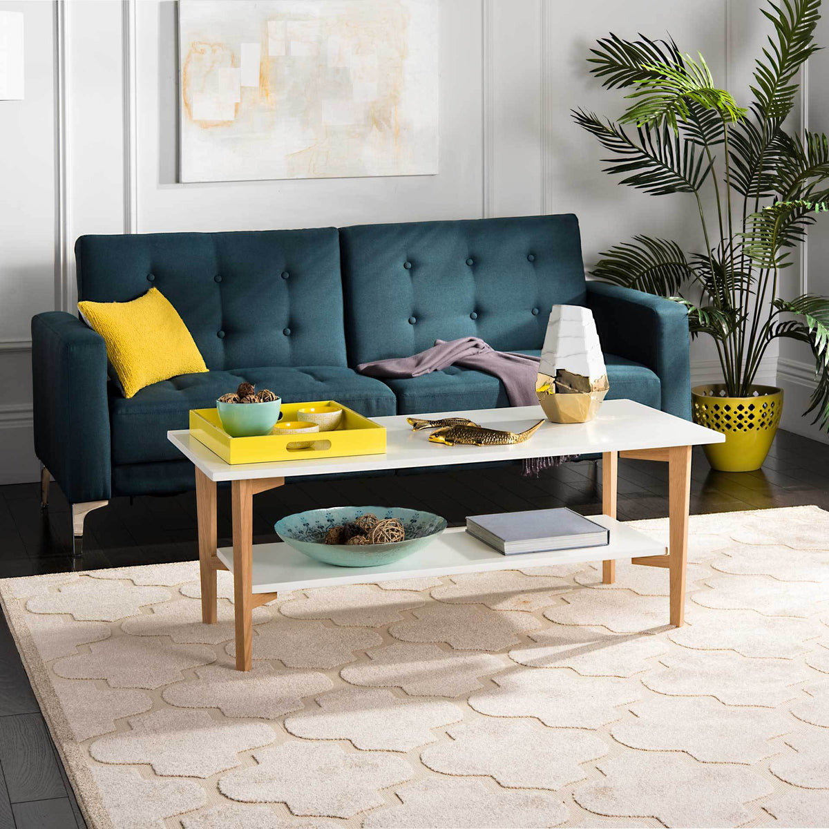 A white two-tier coffee table with natural oak legs brings useful storage and a bright touch to a living room.