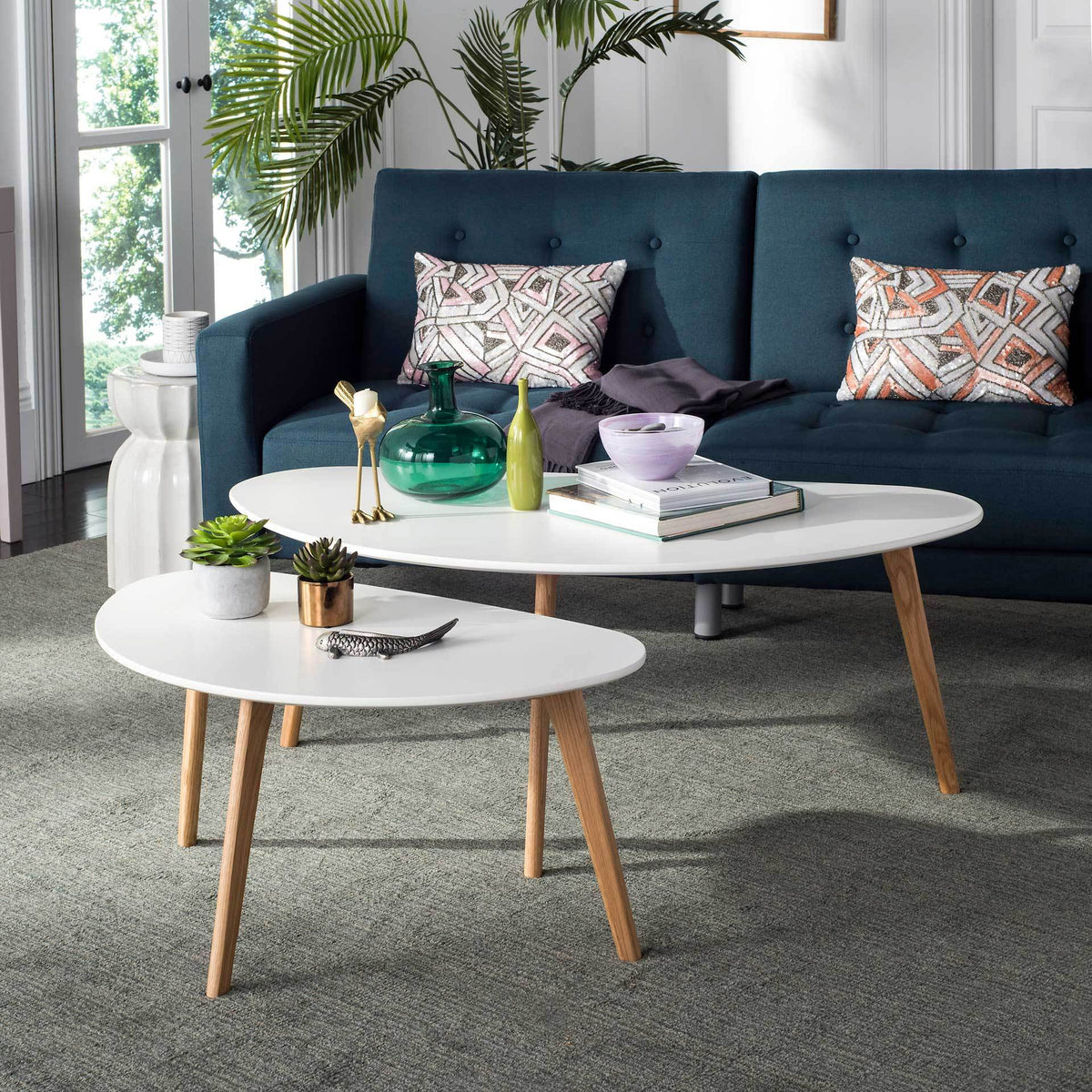 Versatile white coffee tables bring layered surface space and natural oak warmth to the living room.