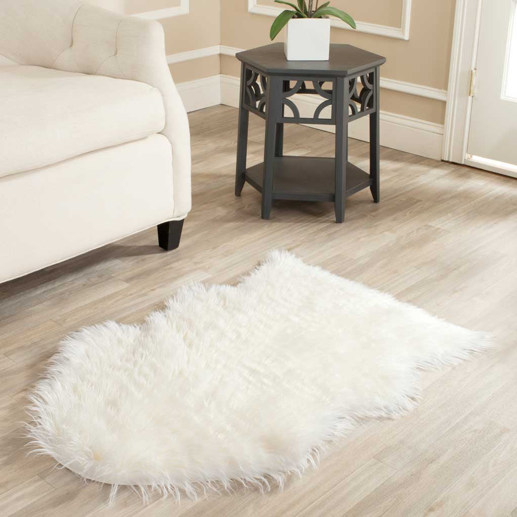 Soft ivory sheepskin-inspired rug brings cozy texture beside a sofa and side table