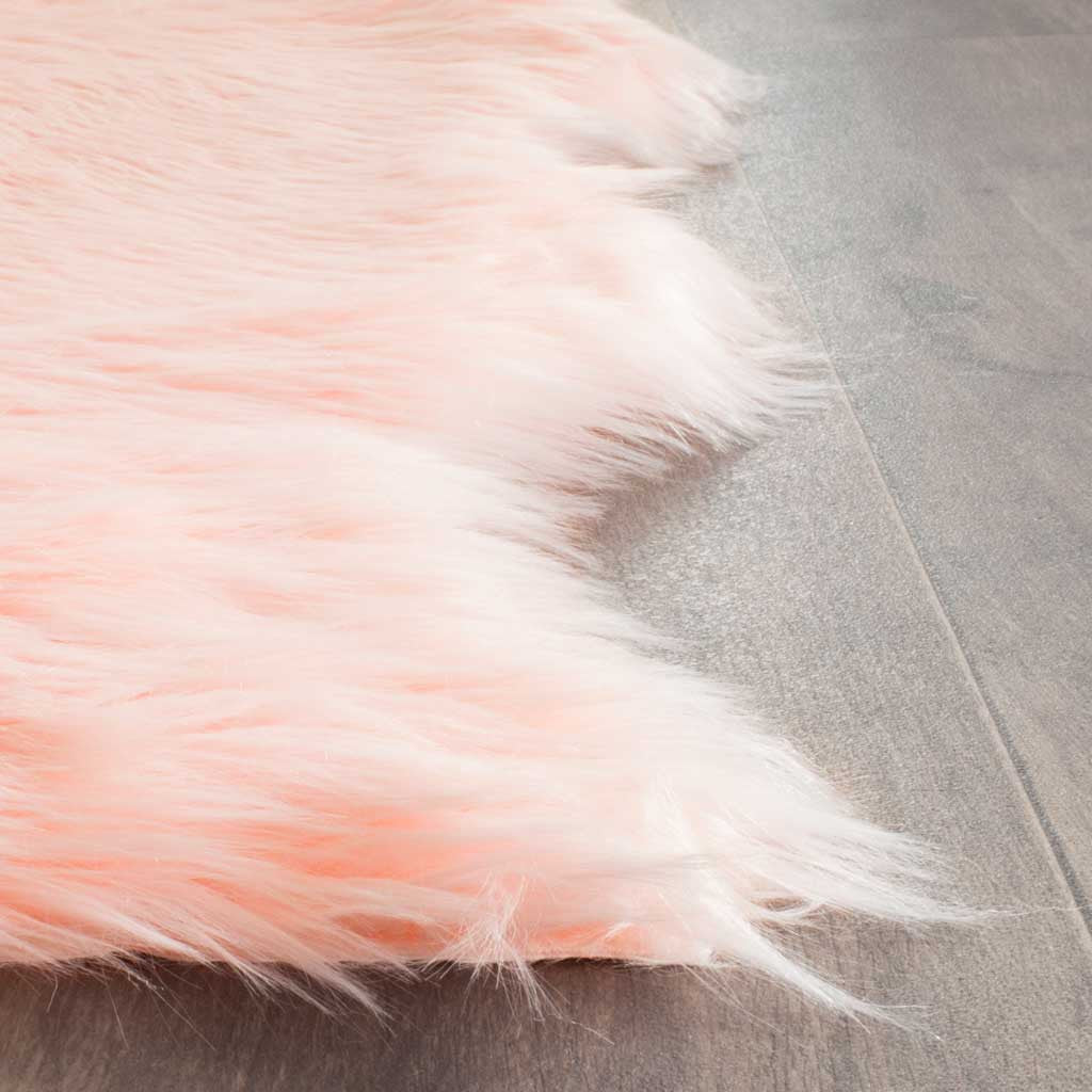 Blush pink shag fibers trail along a soft rug corner for a cozy finish
