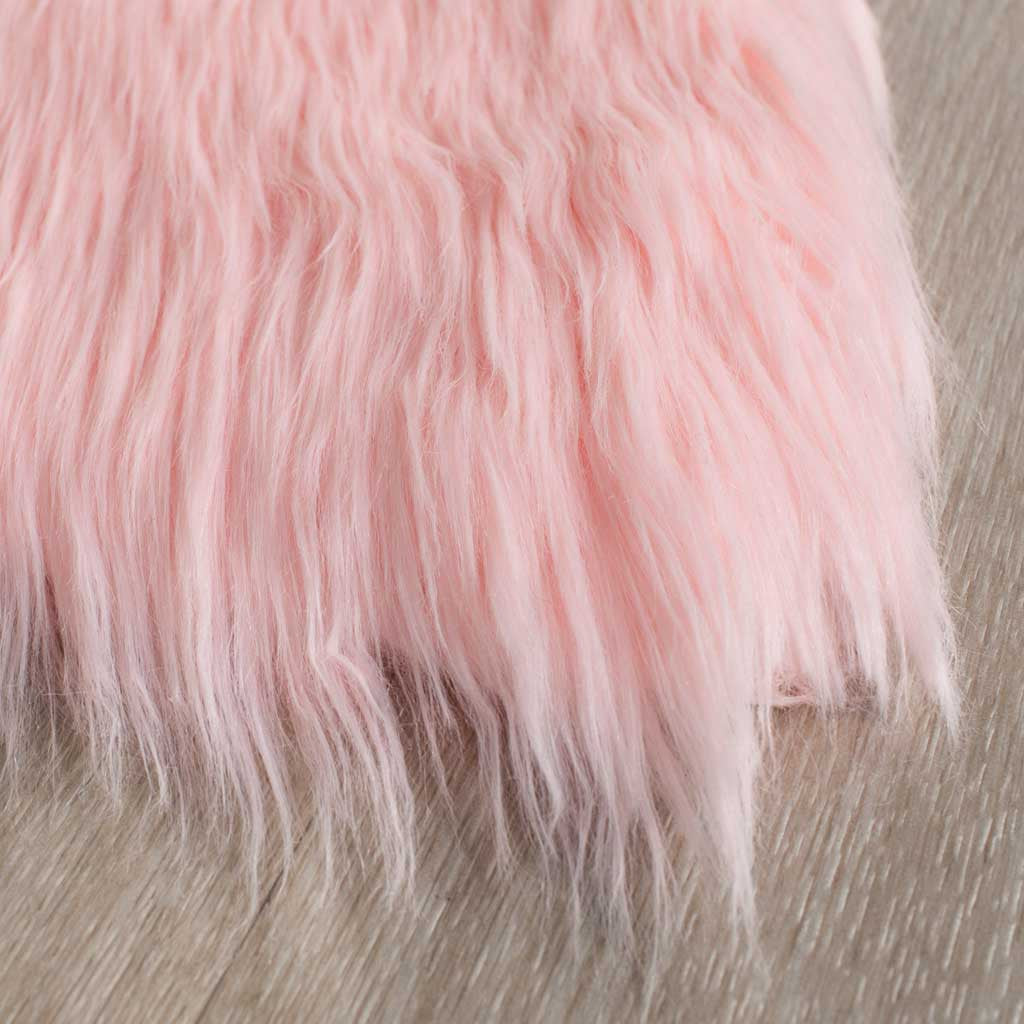 Delicate pink faux-fur fibers feather over the rug's edge in airy, flowing strands