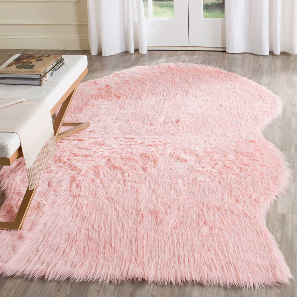 Pale pink hide-shaped rug adds plush, rosy texture beside a modern bench