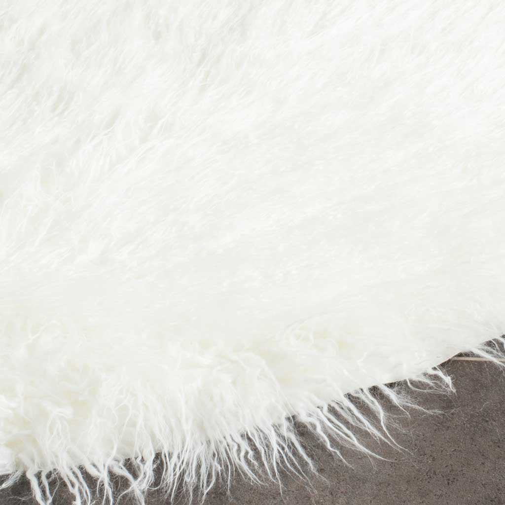 Fine ivory shag fibers extend past the rug's soft edge for an airy finish