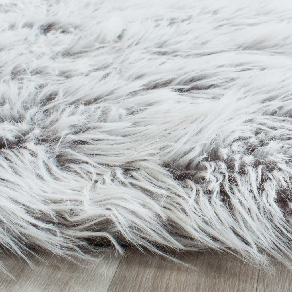 Soft silver-gray faux-fur strands sweep across the rug's textured edge
