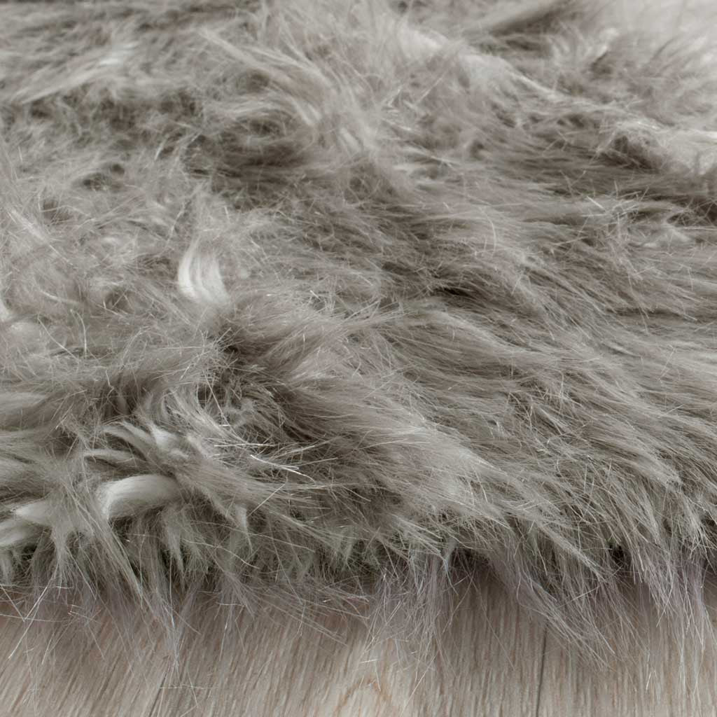 Long gray faux-fur strands gather along the rug's soft, feathery edge