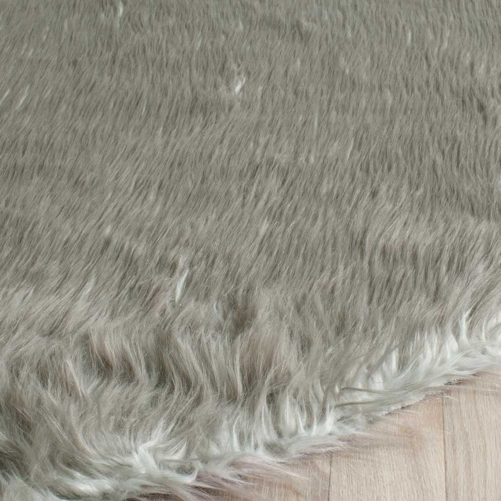 Tapered gray shag fibers soften the edge of this plush faux-sheepskin rug