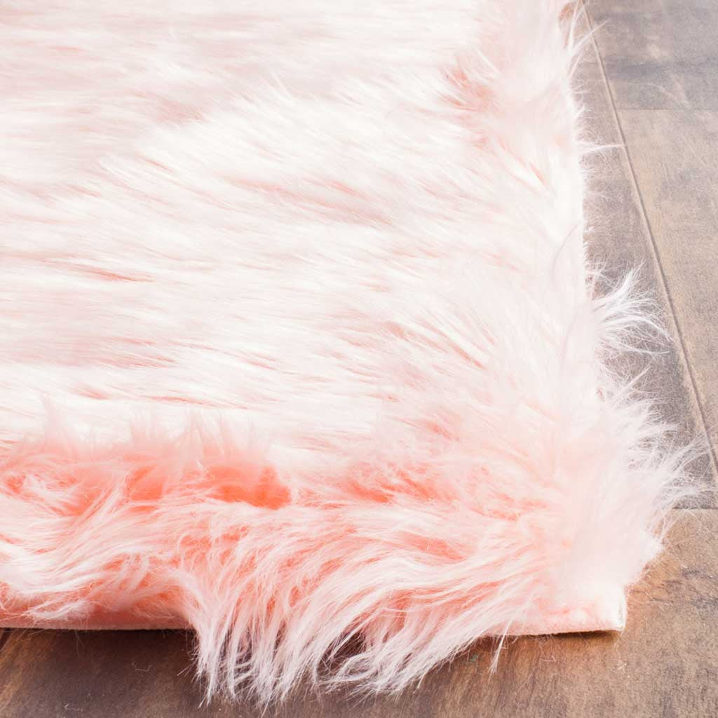 Long pink and ivory shag fibers fan out along the rug's plush corner