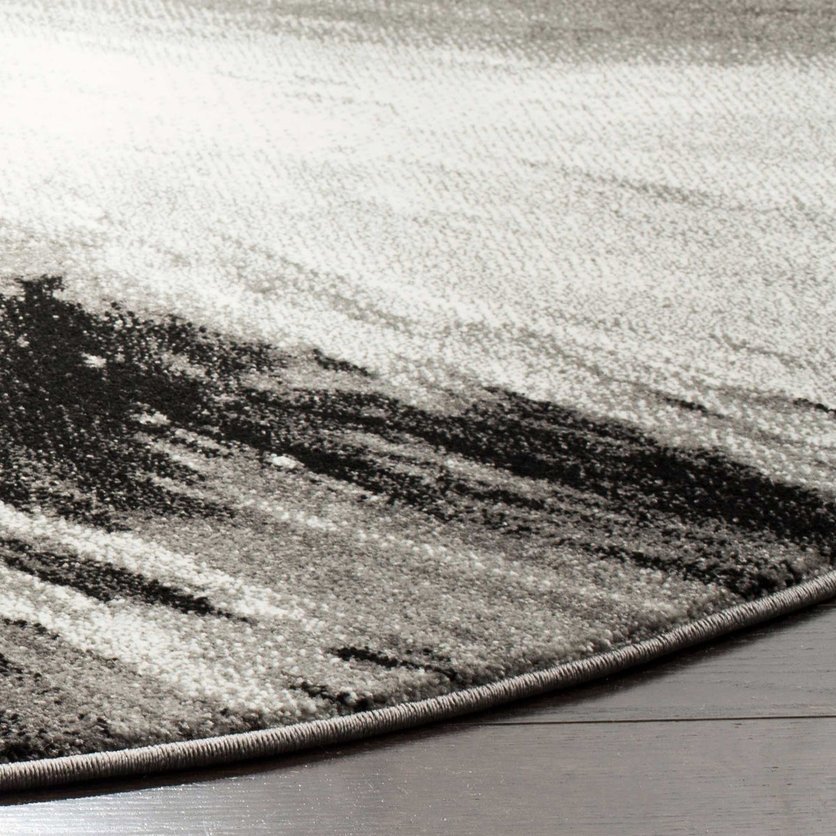 A neatly bound curved edge frames textured ivory, gray, and charcoal markings