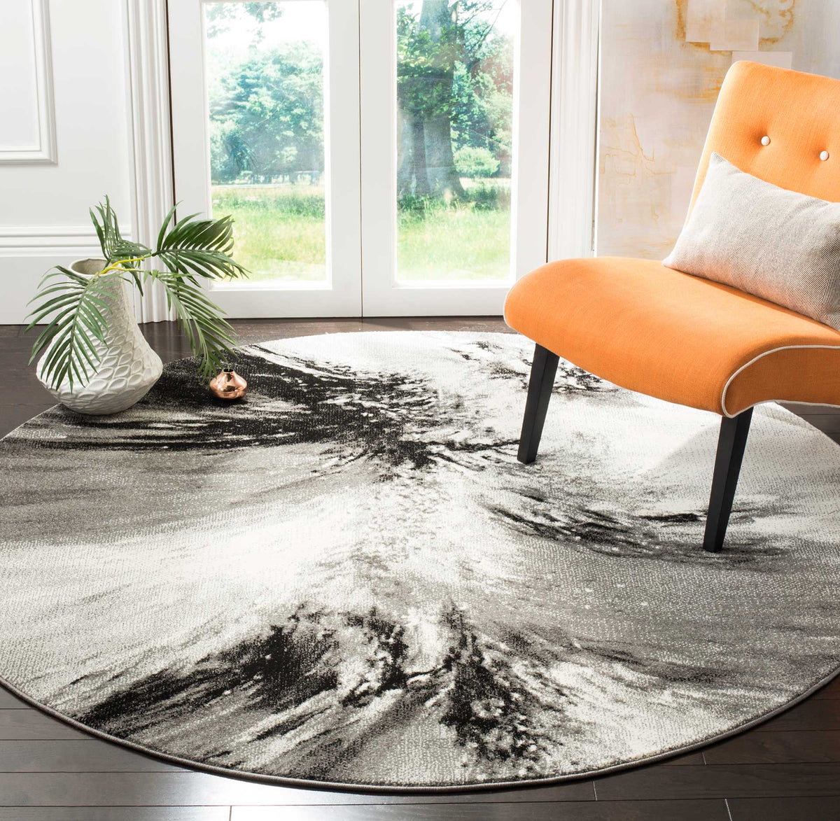 Sweeping charcoal and ivory strokes add contrast beneath a vibrant orange chair