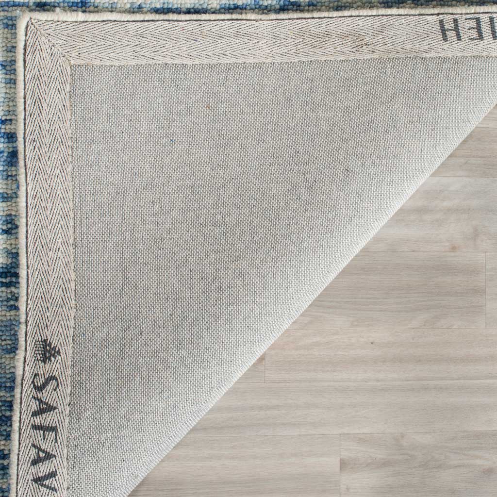 Woven cotton backing and a patterned border add structure beneath the blue wool rug