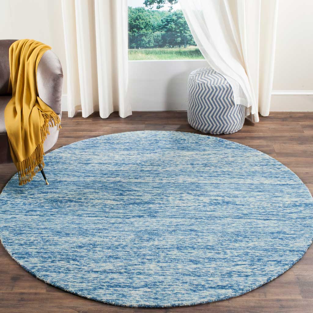 A round blue wool rug brings softly streaked color to warm wood floors
