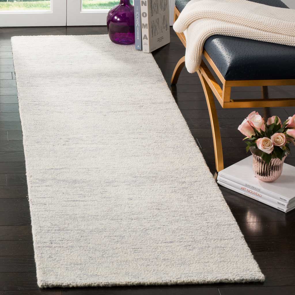Silver wool runner lends gentle texture and airy contrast to dark floors beside a modern bench