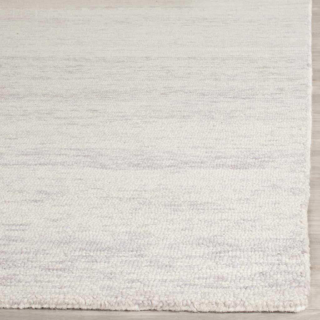 Silver and ivory fibers form a subtle linear texture along the rug's clean edges