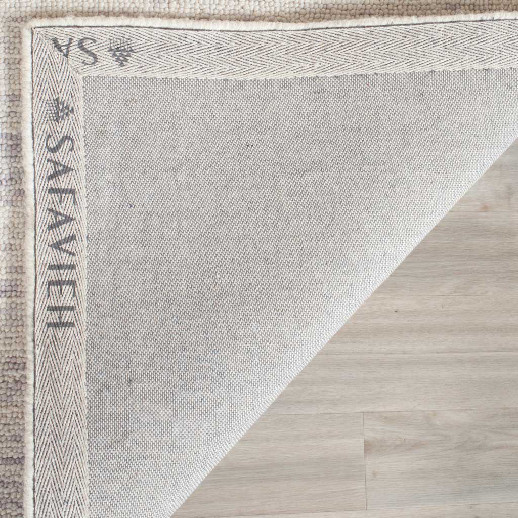 Woven cotton backing and a patterned border add structure beneath the silver wool rug