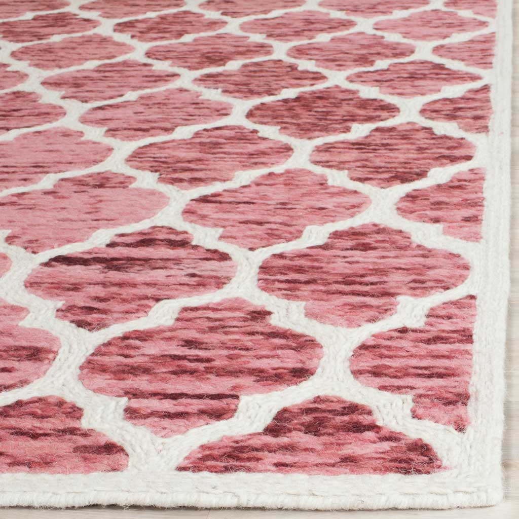 Variegated red wool motifs stand out against a bright ivory lattice and bound edge