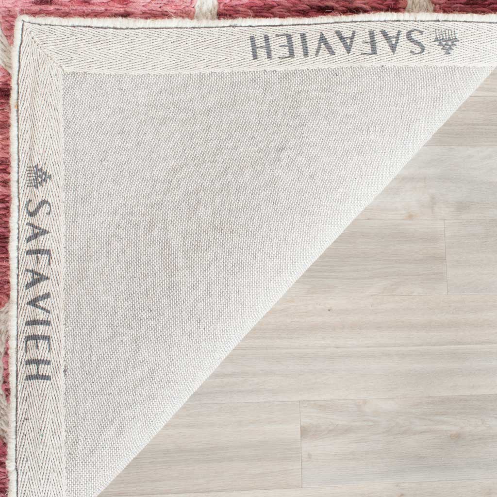 Woven cotton backing and tidy binding finish the underside of the red and ivory rug