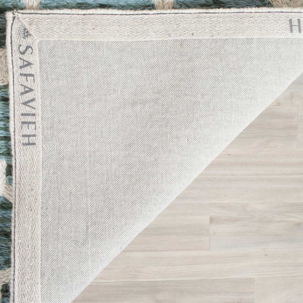 Woven cotton backing and reinforced binding finish the turquoise and ivory wool rug