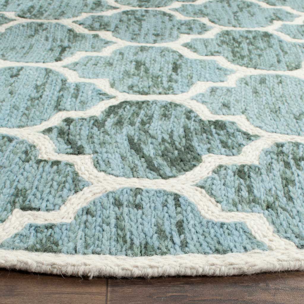 Variegated turquoise wool pile meets raised ivory trellis lines at a finished edge