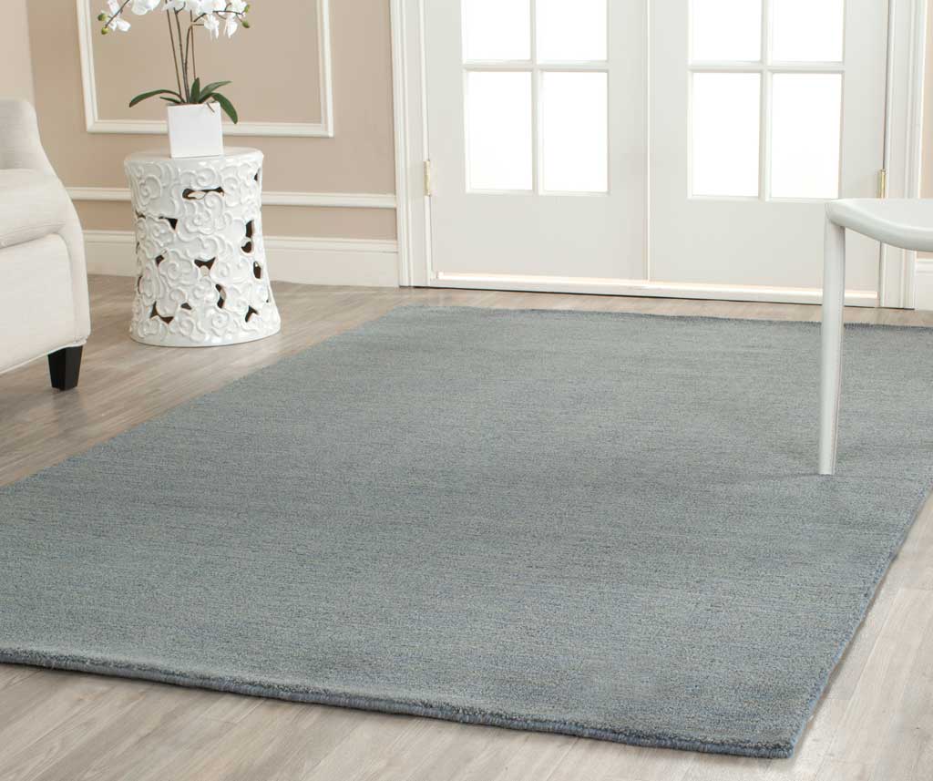 Soft blue rug adds calm, understated color beneath bright furnishings