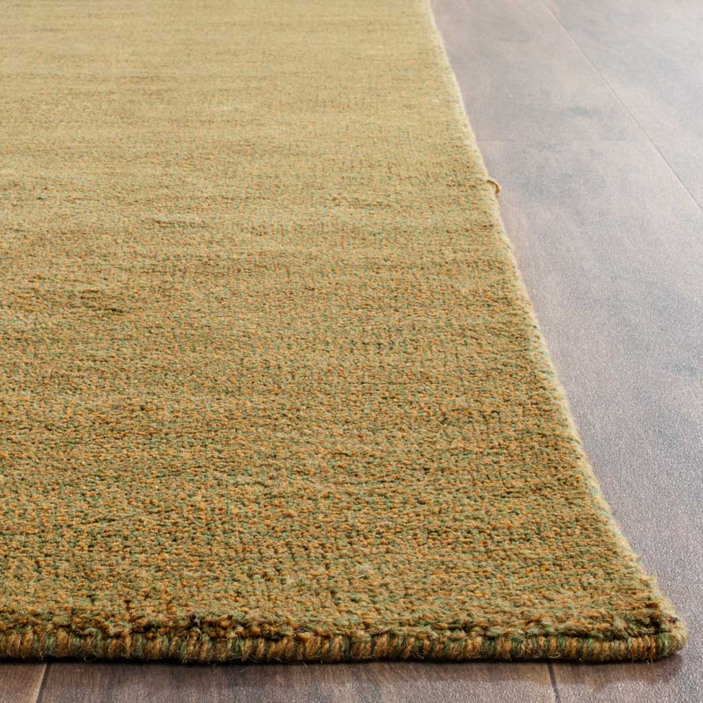 Olive-toned fibers and a neatly finished edge reveal the rug's rich woven texture