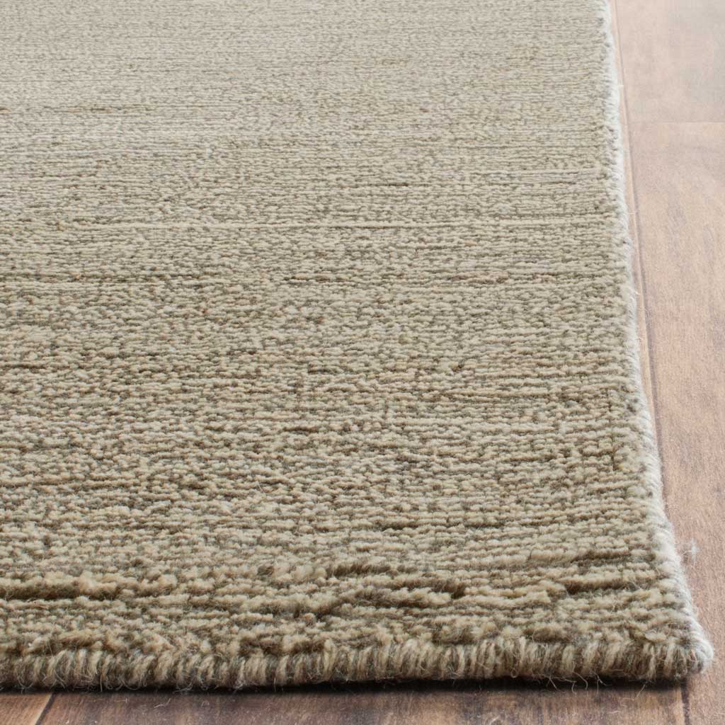 Close-set gray fibers and a finished edge reveal the rug's softly striated surface