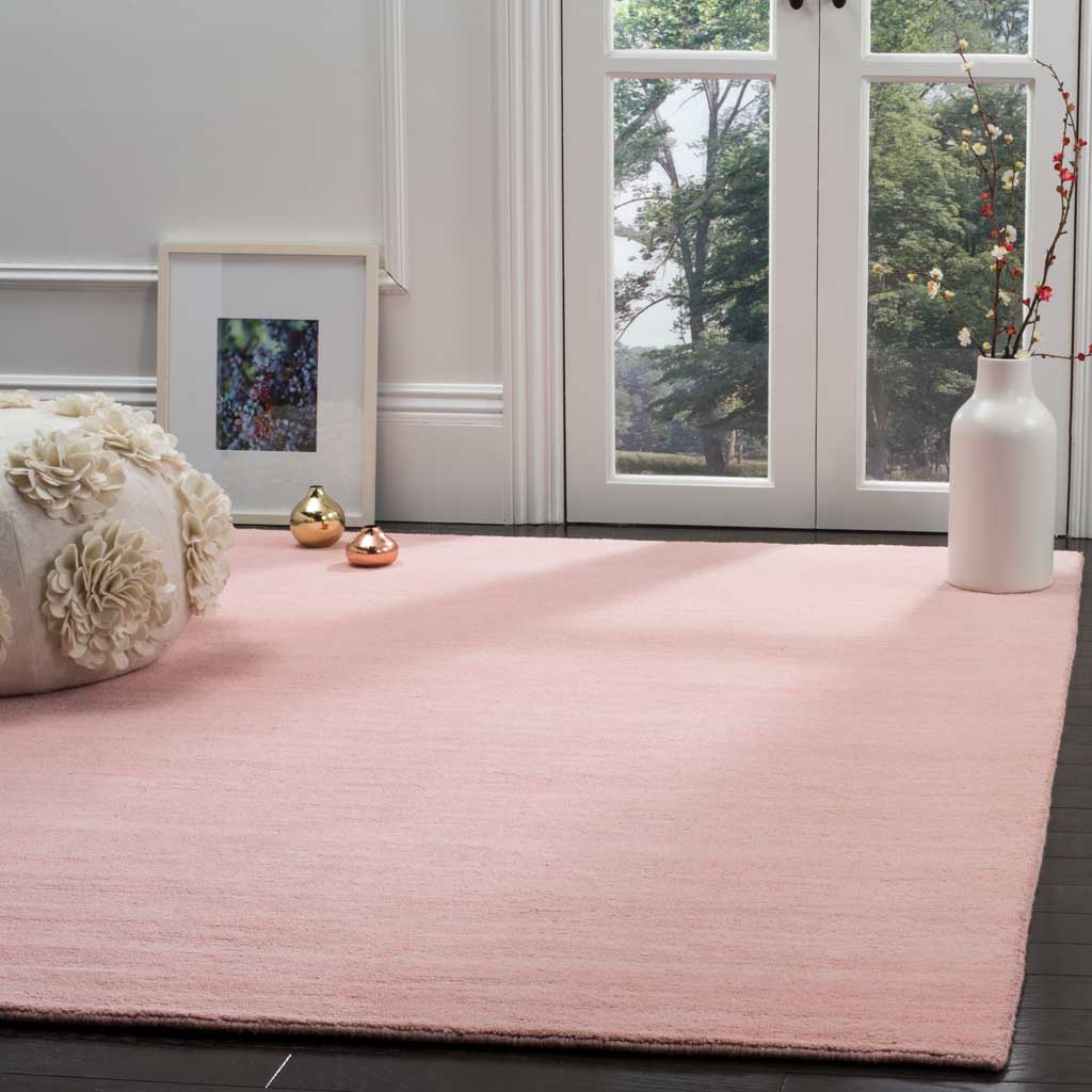 Light pink rug brings a gentle wash of color to a bright room with dark wood floors