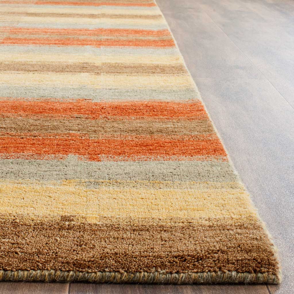 A neatly bound edge frames textured wool stripes in rust, pale gold, gray and brown.
