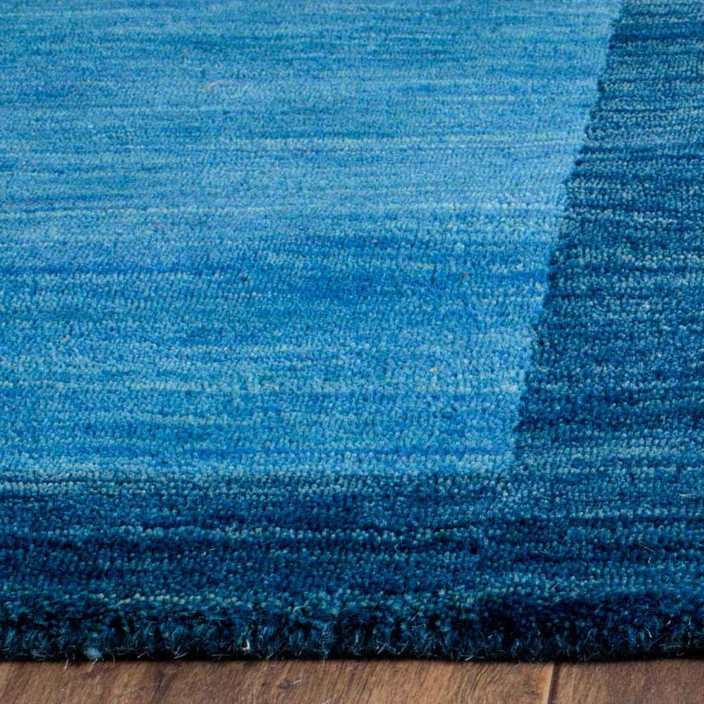 Soft blue wool pile meets a deeper blue border along the rug's edge