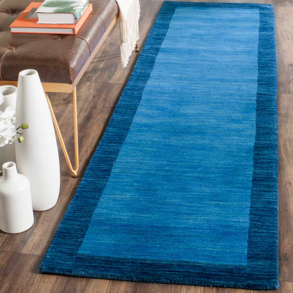 Vibrant blue runner with a dark border adds warmth and color beside a sofa