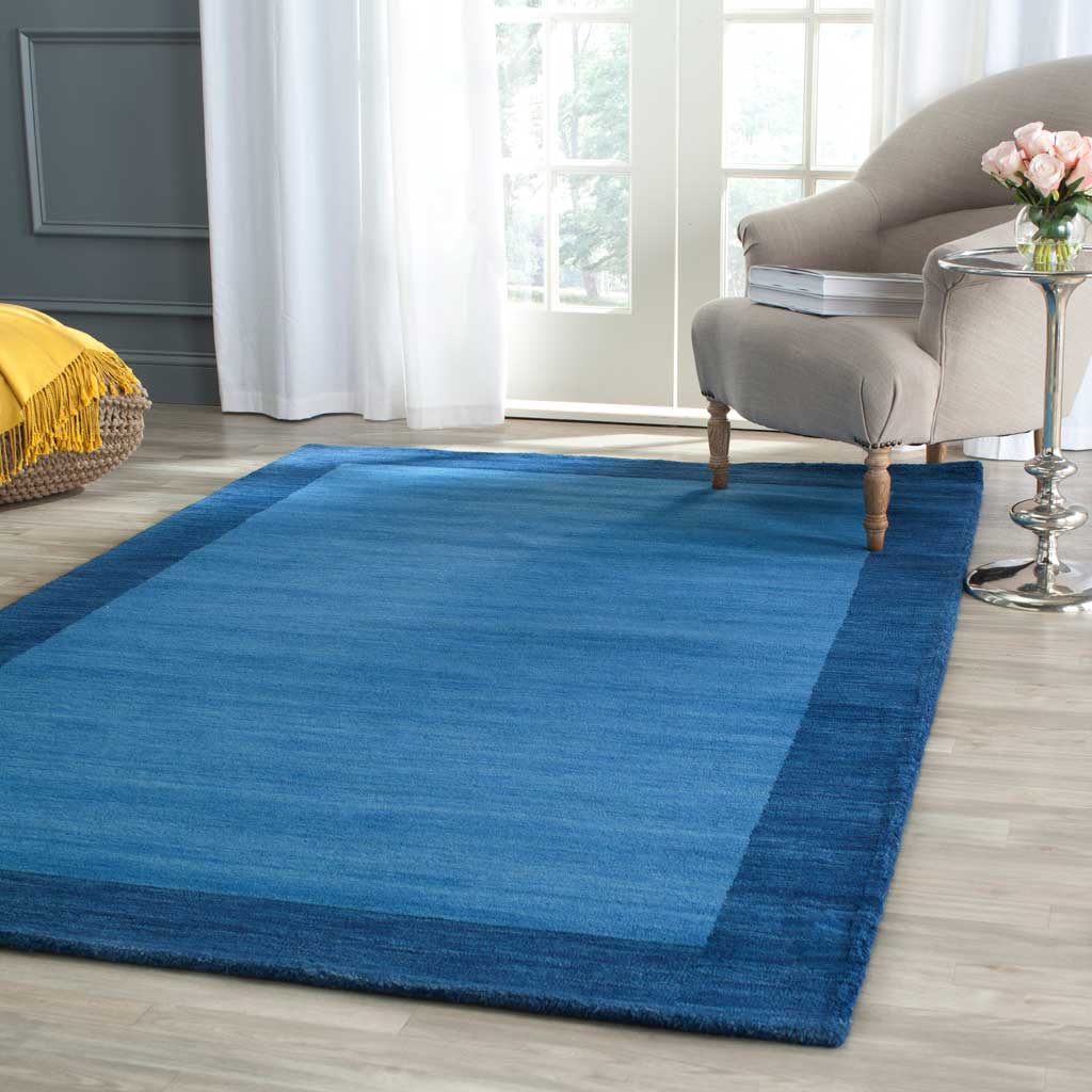A two-tone blue wool rug brings calm color beneath an upholstered chair