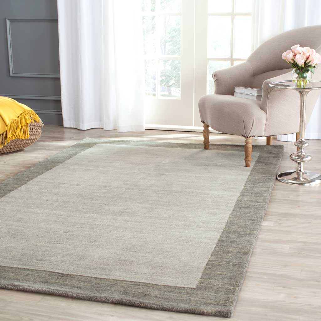 A light gray center and dark gray border add quiet texture beside a cozy chair