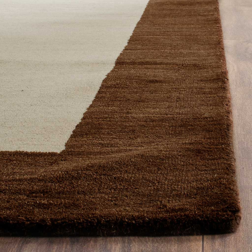 Rich brown border meets a soft beige field, revealing the rug's textured wool pile