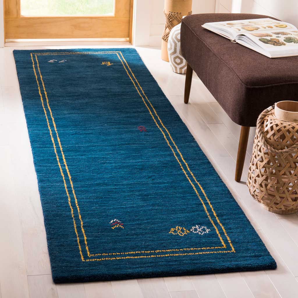 Hand-loomed blue wool runner brings cozy texture and playful motifs to an airy room