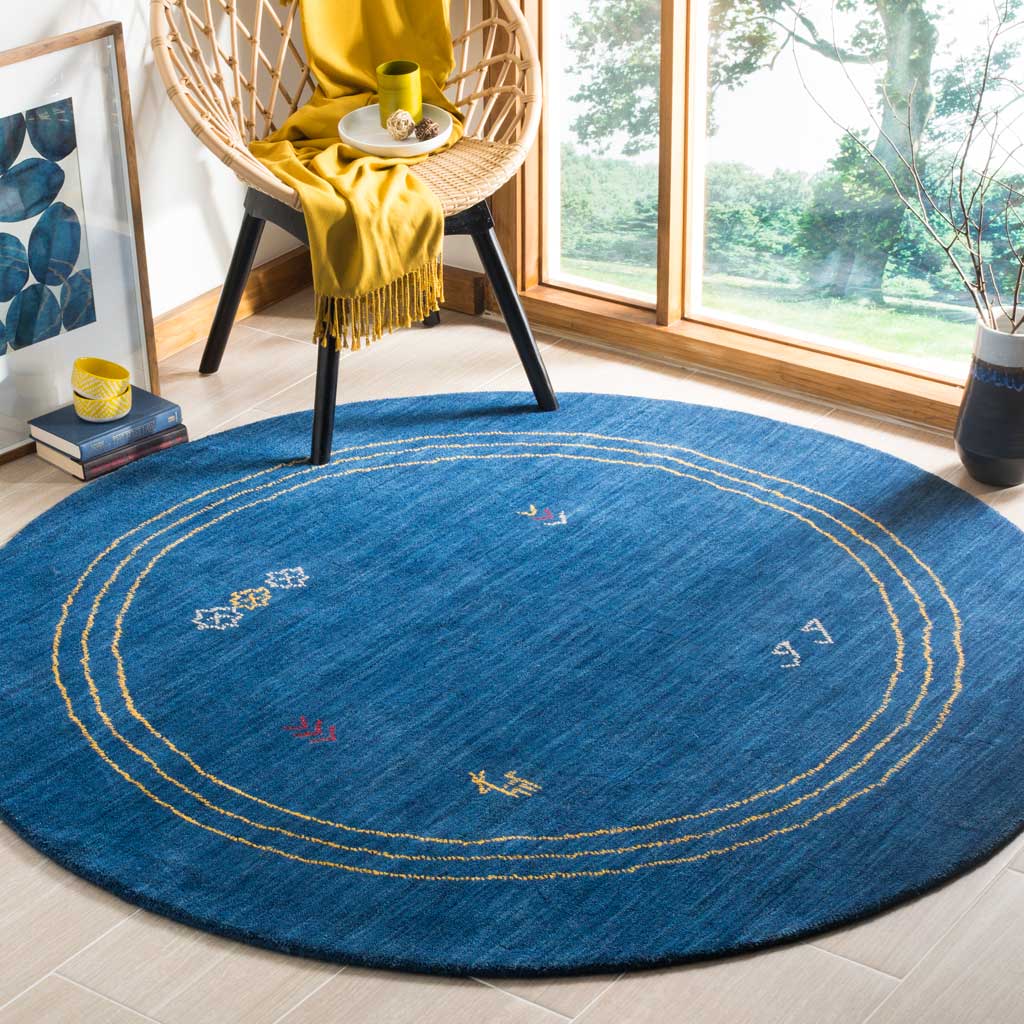 Deep blue round rug adds gold rings and colorful accents to a sunlit room