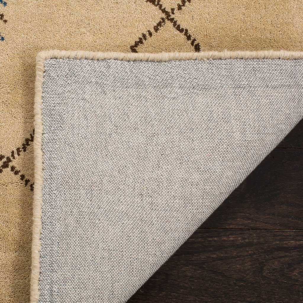 Woven cotton backing and a finished edge beneath the beige, patterned wool pile