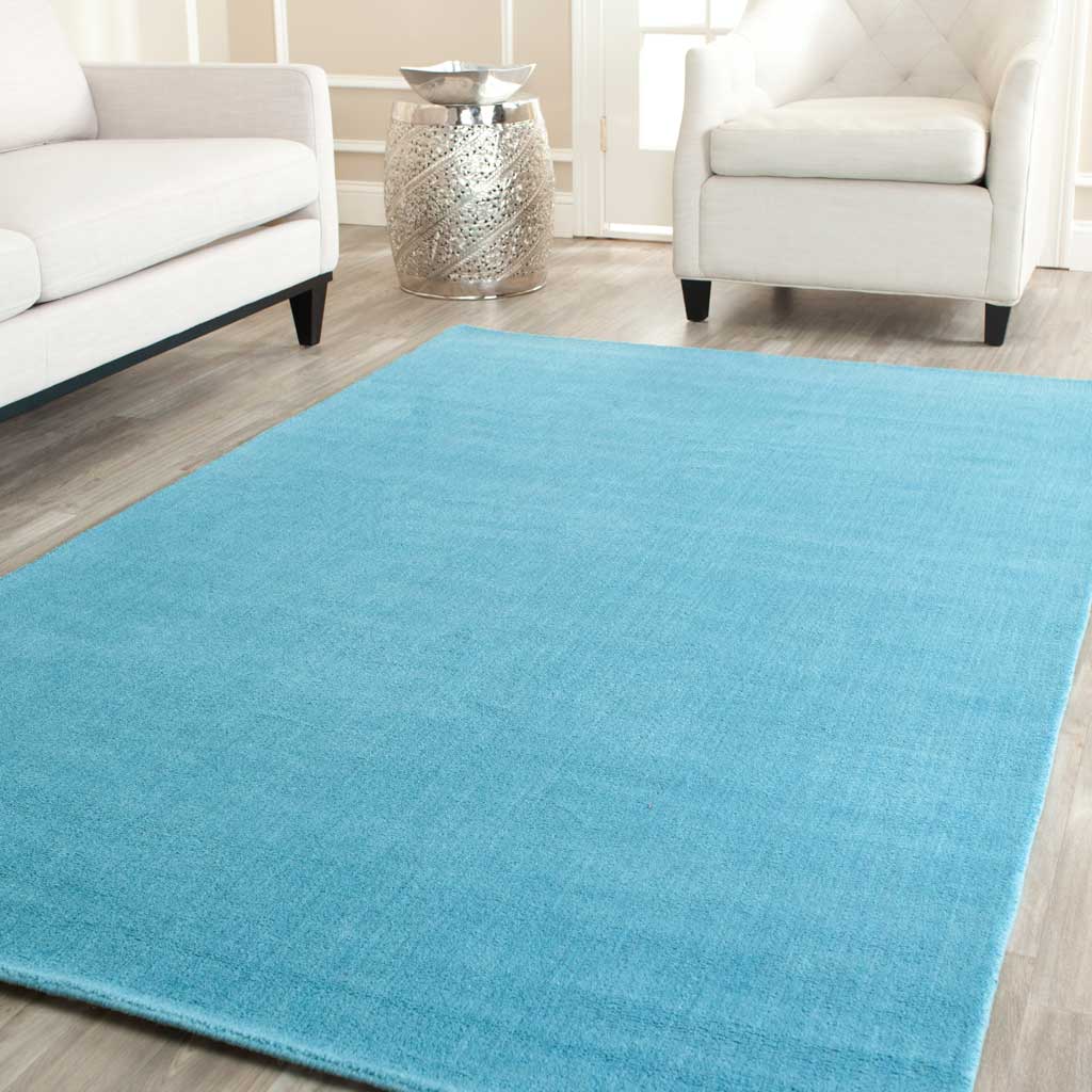 Turquoise area rug adds a lively yet calming layer to a bright living room