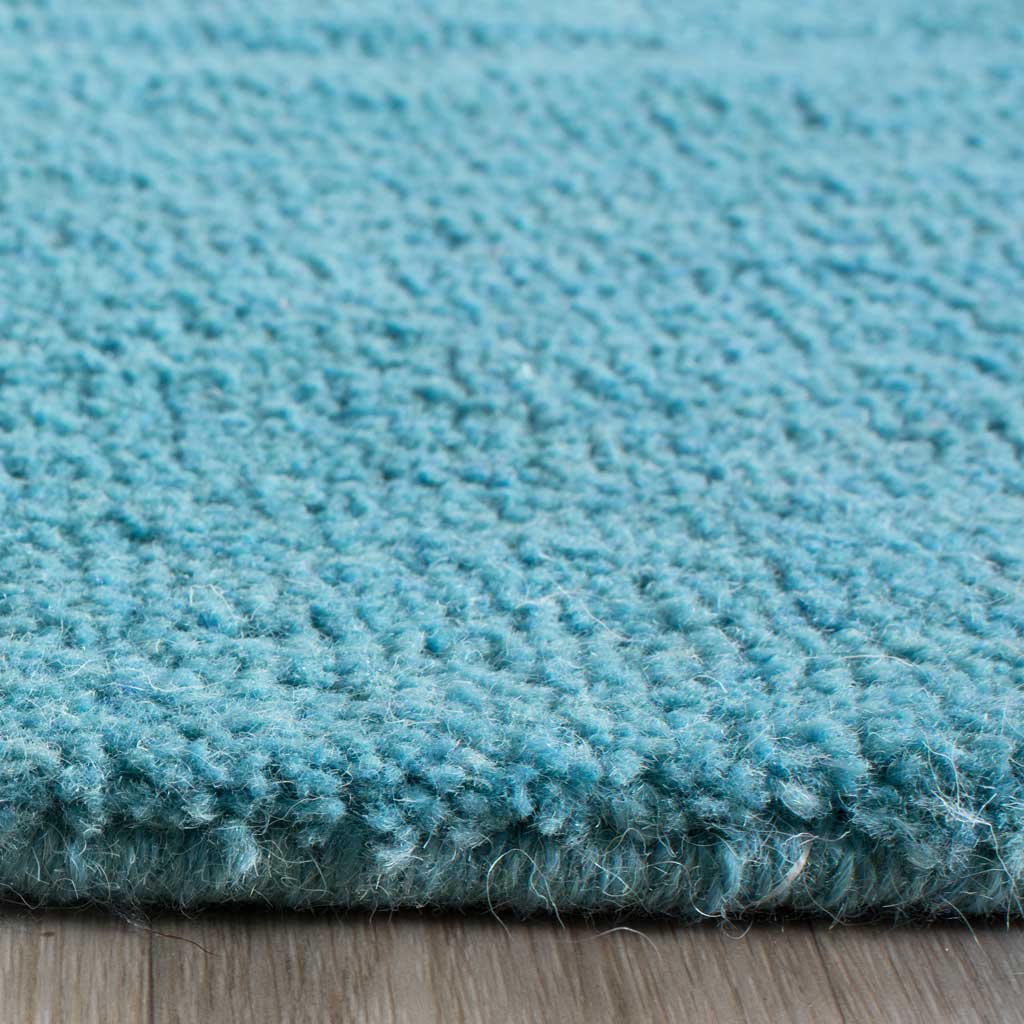 Dense turquoise pile reveals a cushioned texture and neatly finished edge