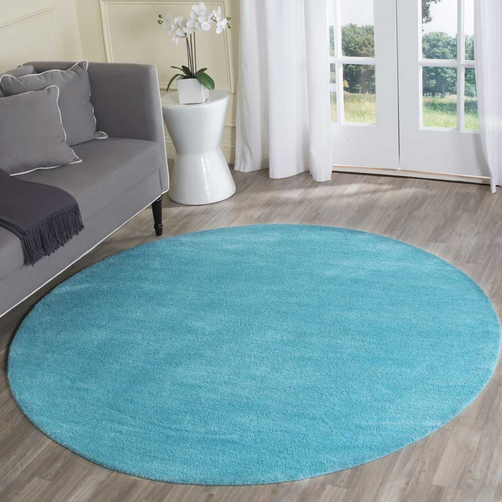 Bright turquoise round rug adds a soft, refreshing accent to a cozy seating area
